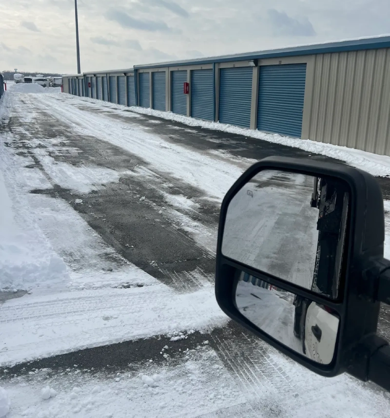 A truck is parked on the side of a road in snow.